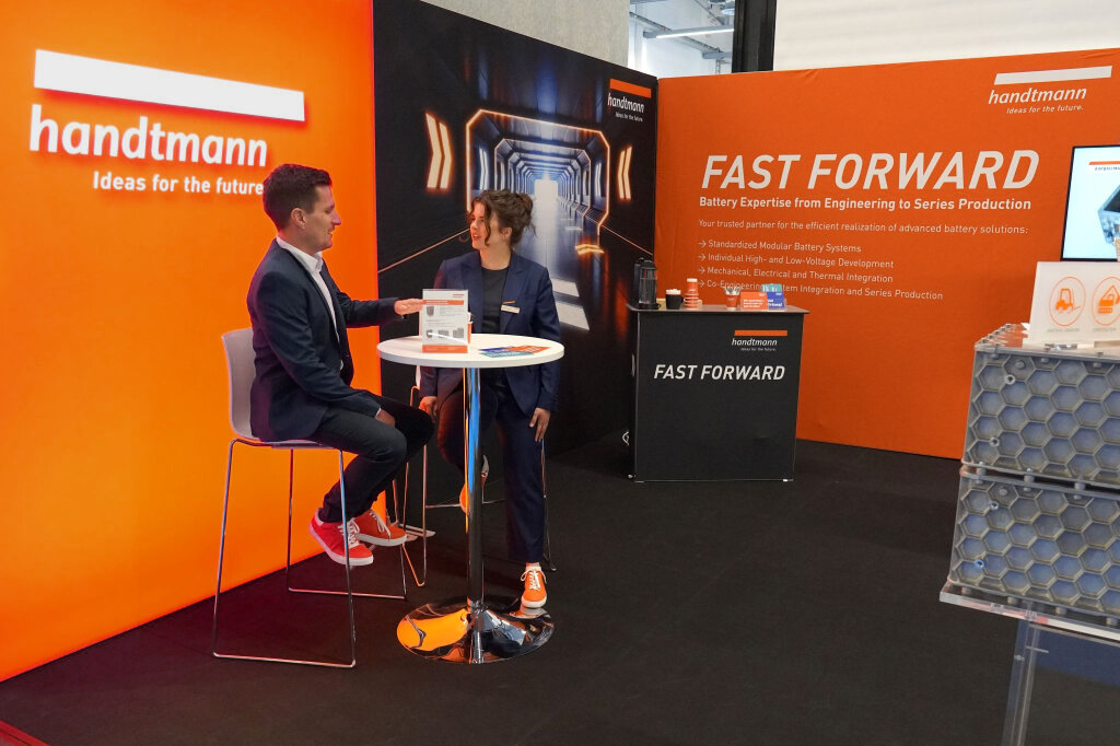 Messestand von Handtmann Systemtechnik mit dem von SYNBRAND entwickelten FAST FORWARD-Konzept, neuer Bildwelt und orange-schwarzem Messedesign.