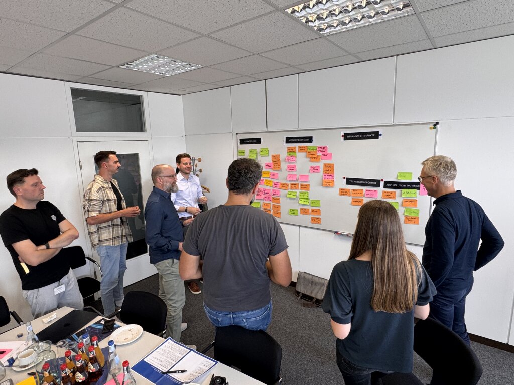 SYNBRAND und Handtmann Systemtechnik diskutieren im Markenstrategie-Workshop verschiedene Positionierungsans&auml;tze an einem Whiteboard mit farbigen Post-its.