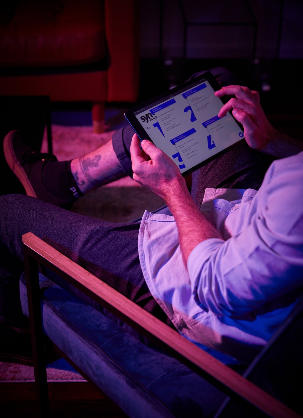 SYNBRAND-Mitarbeiter betrachtet auf einem Tablet die vier Phasen des Branding-Prozesses.