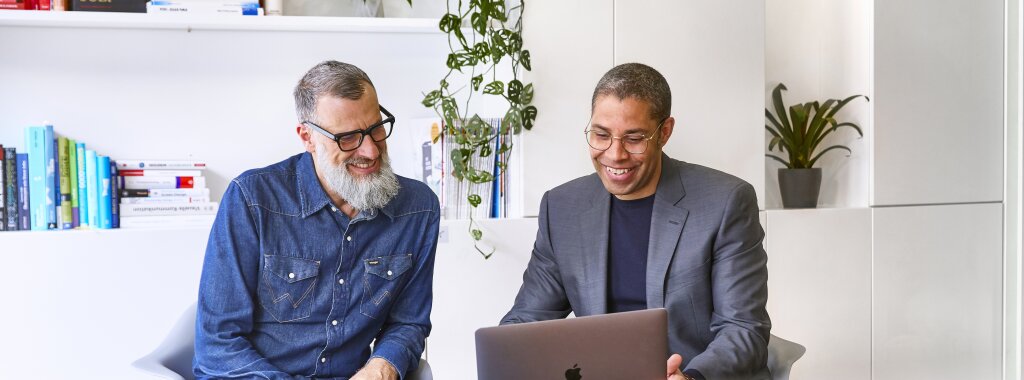 SYNBRAND-Berater im gemeinsamen Austausch zur strategischen Markenentwicklung am Laptop.