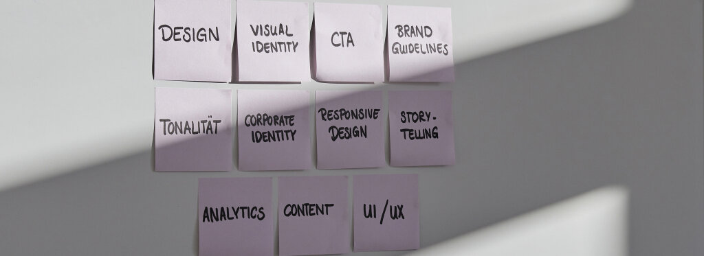 Post-its an einer Wand mit Begriffen wie Design, Markenidentit&auml;t, Brand Guidelines, Storytelling, Analytics und UX/UI.